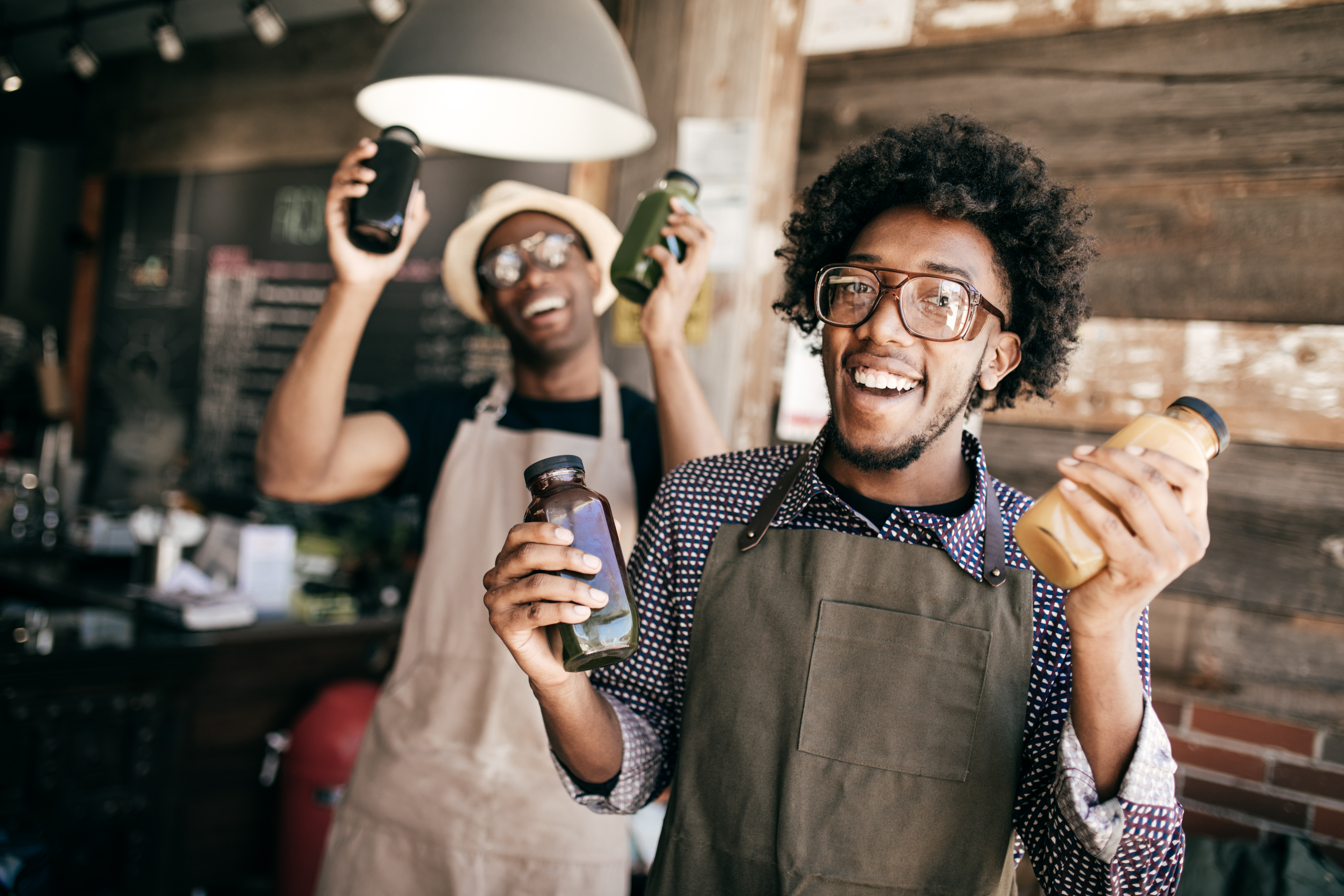 Men Holding Bottles of Juice 